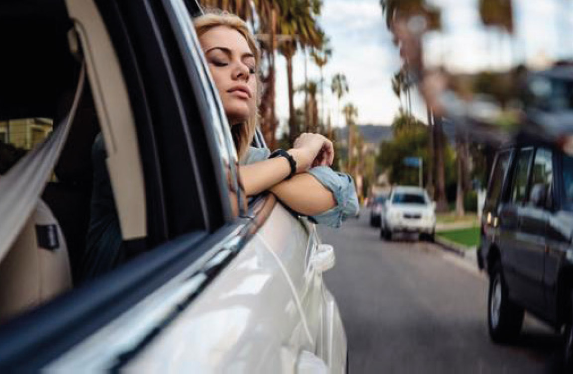 Image of a young woman looking out of a car window