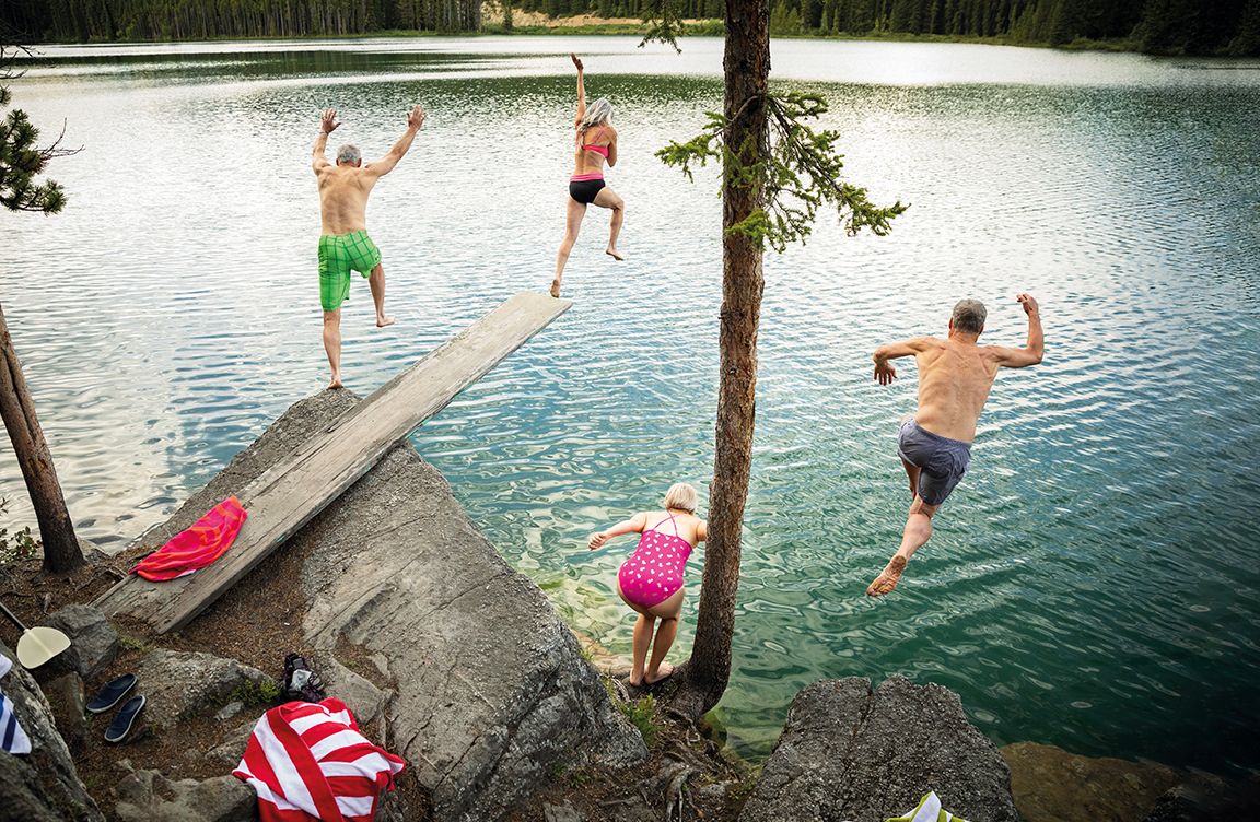  Four people jumping into a lake.